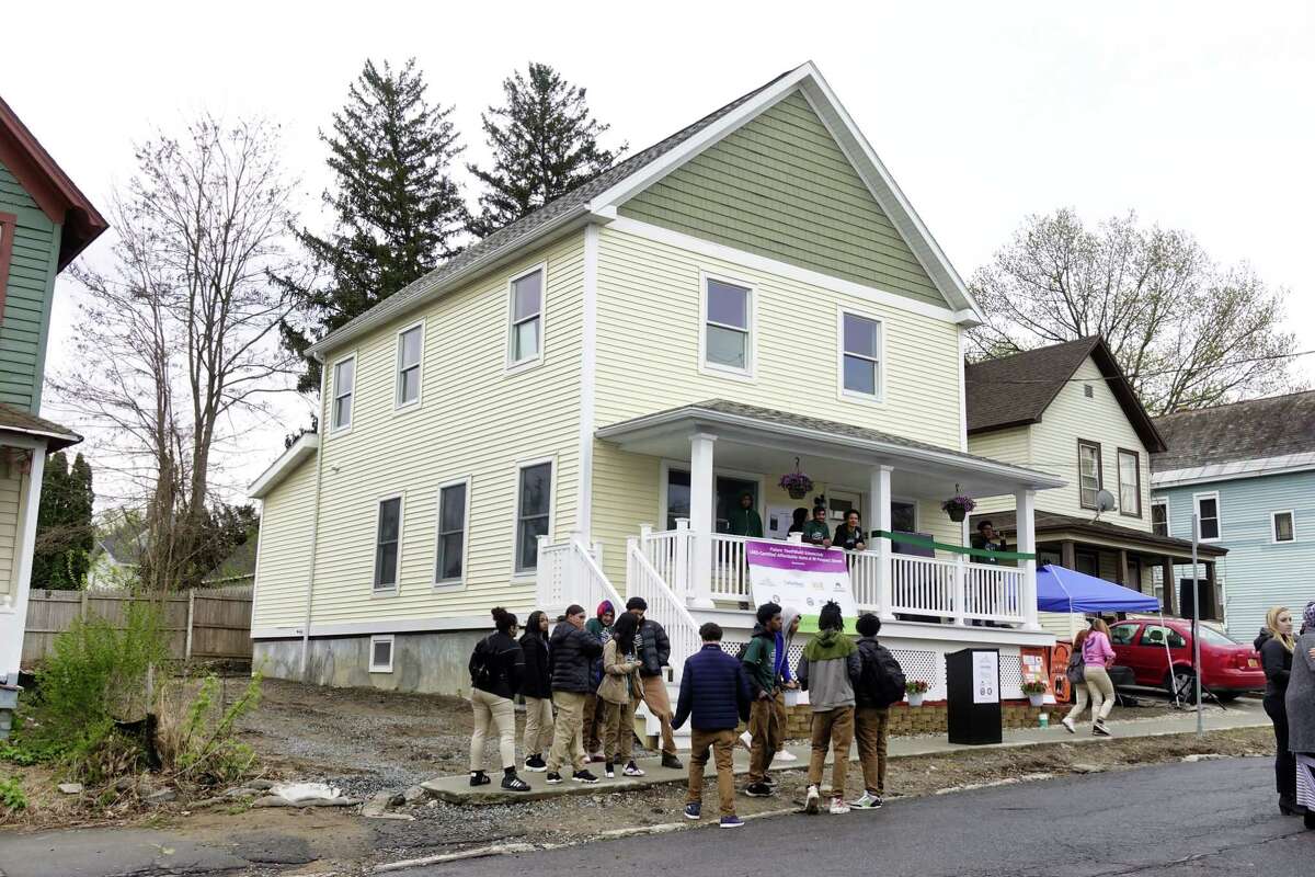 People gather for an event outside of a new net-zero home at 101 Prospect Street, that was built by YouthBuild Schenectady students in partnership with Saint-Gobain on Wednesday, May 1, 2019, in Schenectady, N.Y. (Paul Buckowski/Times Union)