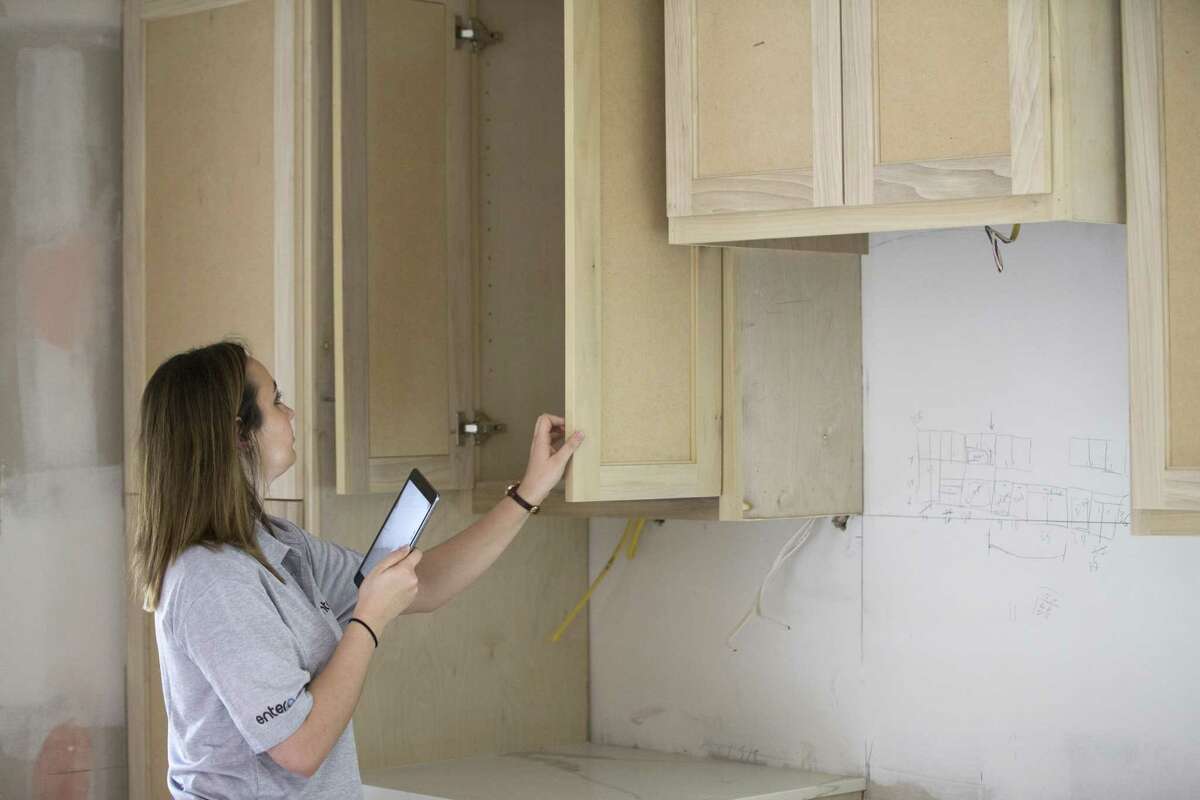 Bailee Wright, transaction coordinator for Entera, inspects and takes photos of progress on a home remodel for an institutional investor on Friday, March 8, 2019, in Houston.