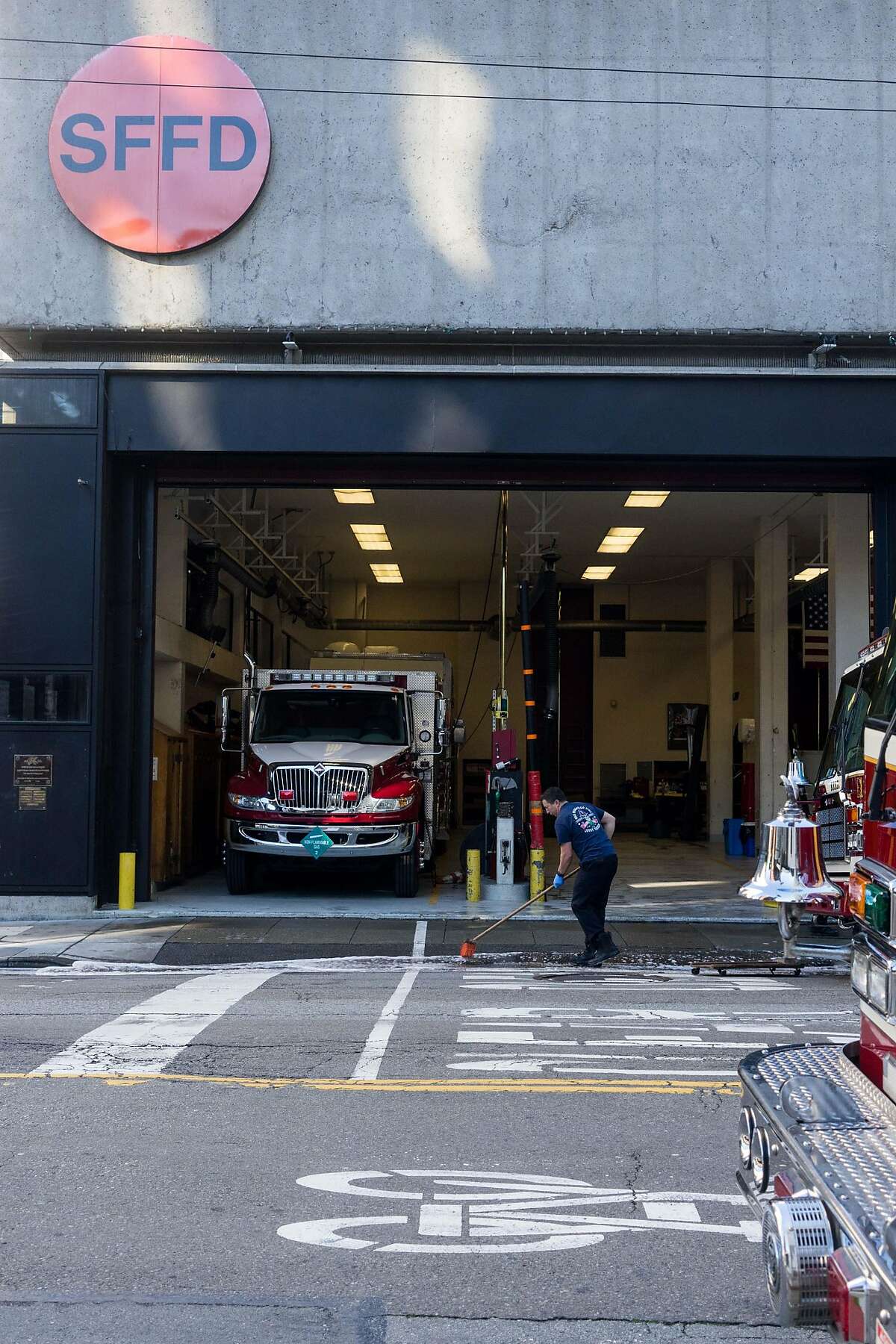A firefighter cleans in front of the station at 530 Sansome St. in San Francisco, Calif. on Monday, Jan. 21, 2018. The city is proposing building a fire station and housing at 530 Sansome Street and then use that money from that sale to build affordable housing at 772 Pacific Avenue.