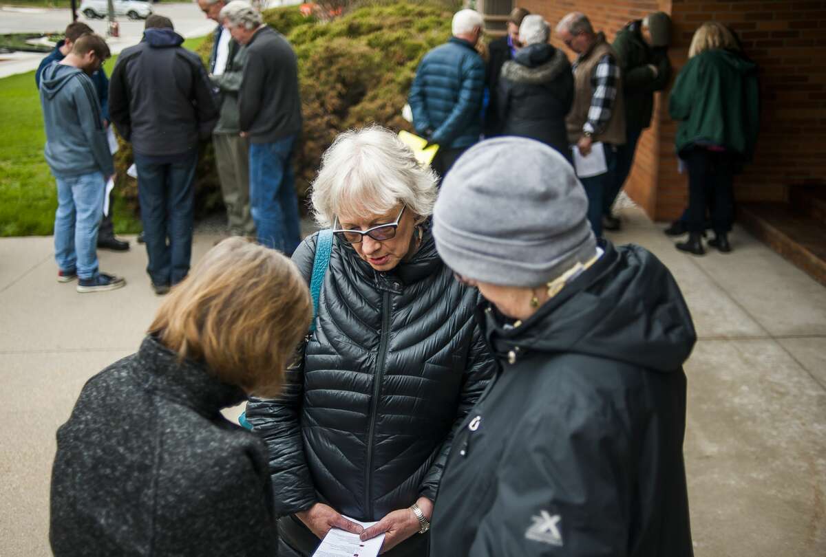Susan Kingsley, center, prays with two others during a gathering in observance the National Day of Prayer on Thursday, May 2, 2019 on the front steps of First United Methodist Church. Worshippers broke off into groups of 2-6 people and prayed for eight different groups: government, military, media, business, education, church, family and society. (Katy Kildee/kkildee@mdn.net)