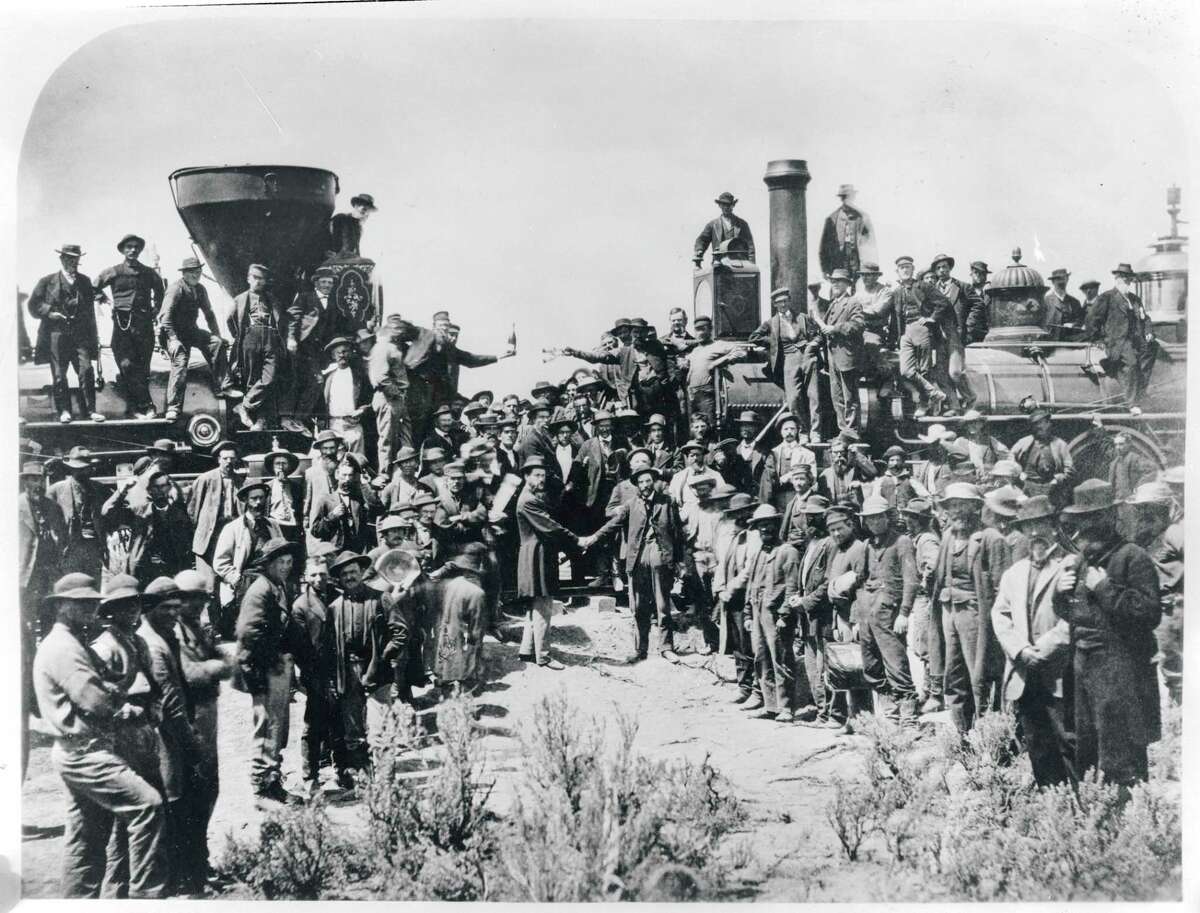 Railroad workers celebrate at the driving of the Golden Spike Ceremony in Utah on May 10, 1869 signifying completion of the first transcontinental railroad route created by joining the Central Pacific and Union Pacific Railroads.