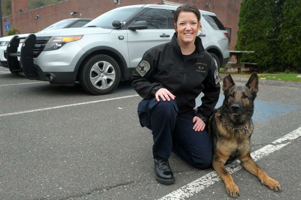 Trooper First Class Jessica Genest poses with her K-9 Asher during an interview at the Connecticut State Police Troop A barracks in Southbury, Conn. May 3, 2019.