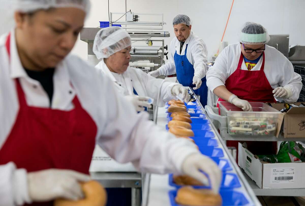 Workers assemble a variety of school lunches while at the Lunch Master facility in San Carlos, Calif., Friday, May 3, 2019.