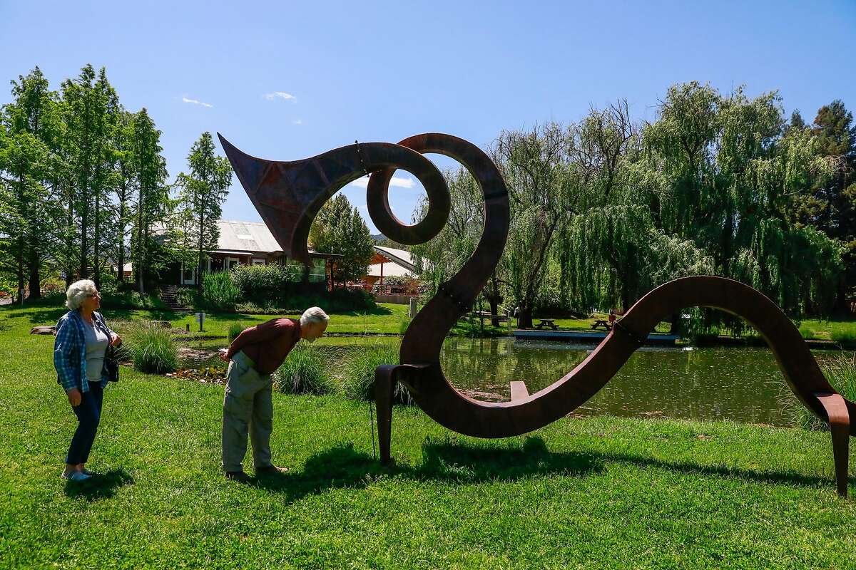 Donna and Charlie (last names preferred to be anonymous) check out the serpent sculpture at the Solar Living Center in Hopland, California, on Wednesday, May 1, 2019. Flow Kana recently bought the 12-acre property and will invest money into it to make it a visitors center.