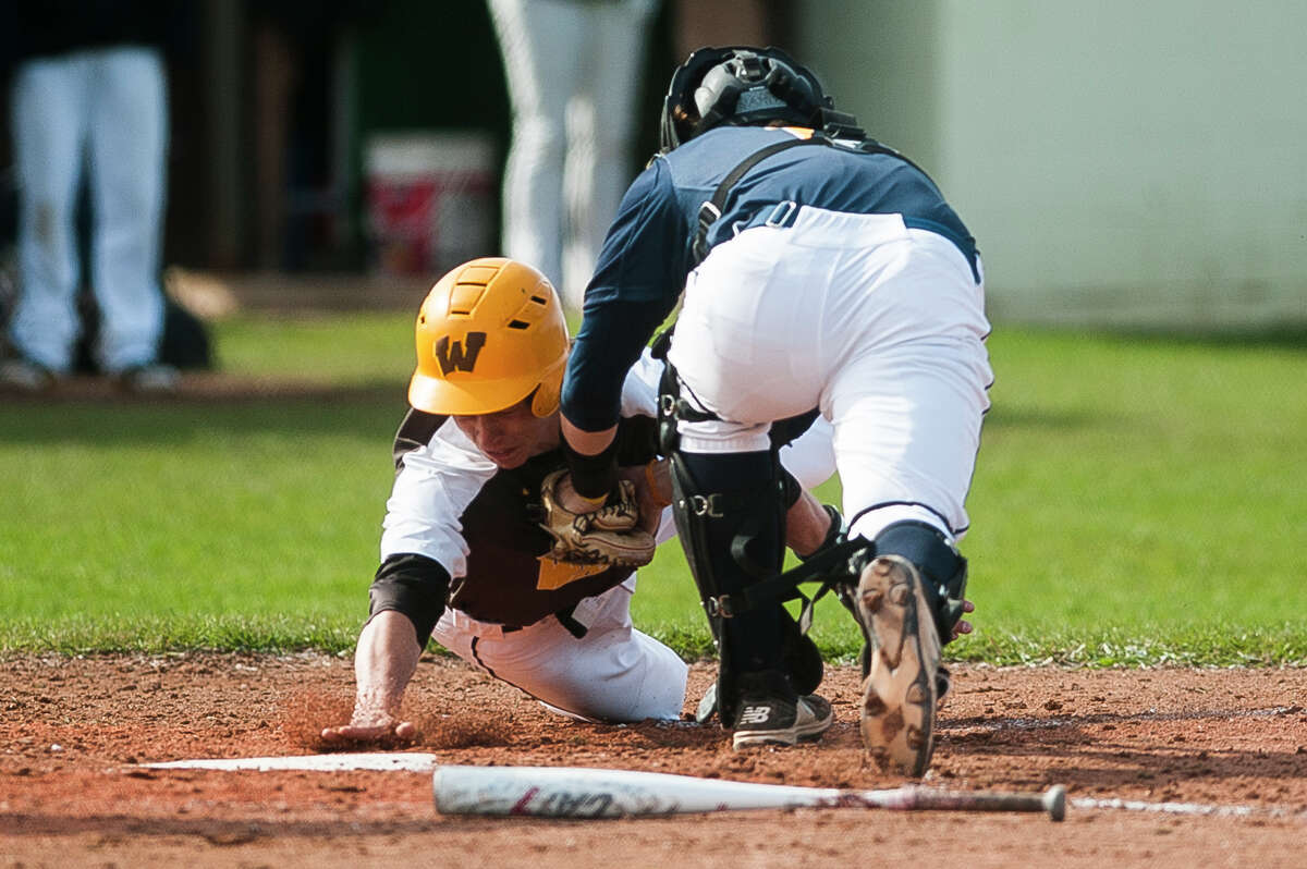 Bay City Western's Nick Dardas dives toward home plate in an attempt to score a run during a game against Midland on Friday, May 3, 2019 at Bay City Western High School. (Katy Kildee/kkildee@mdn.net)
