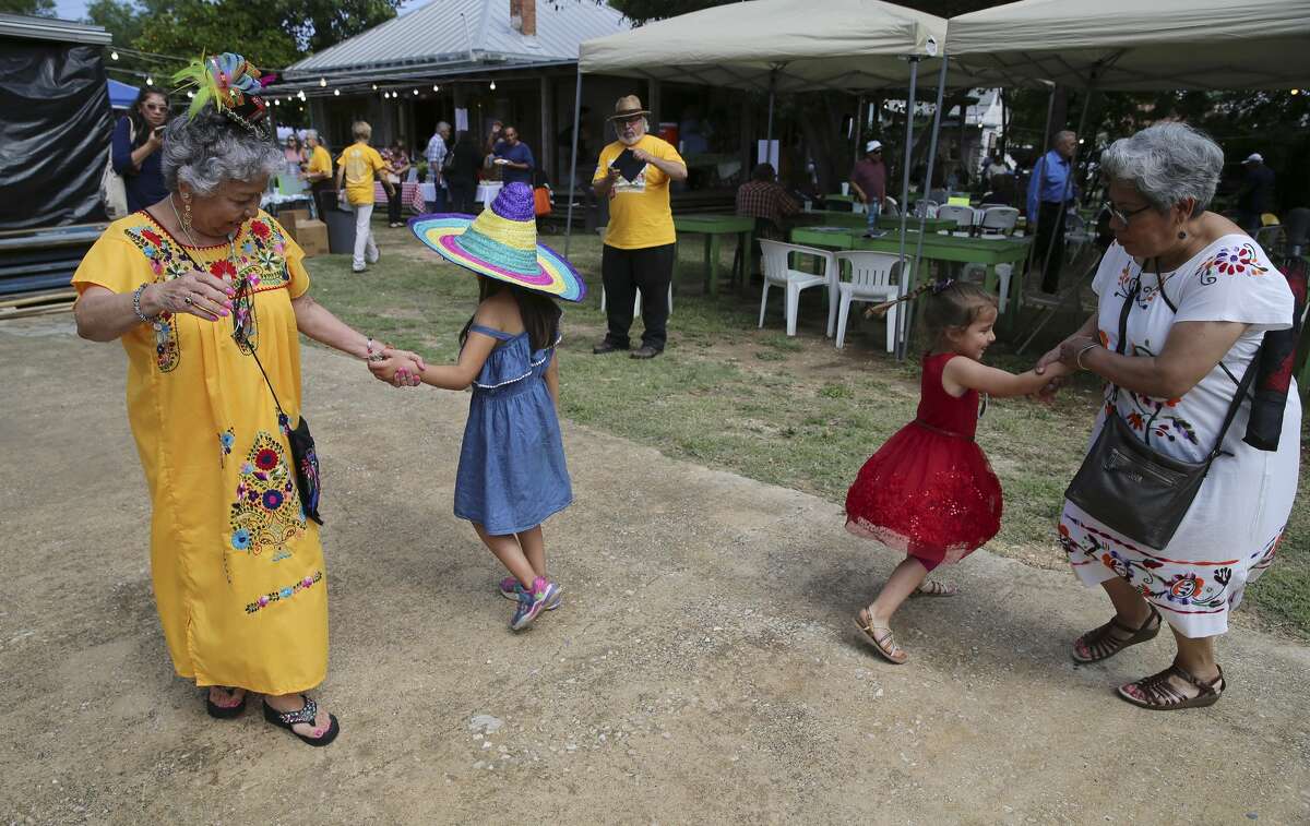Olga Martinez (left) dances with six-year-old December Martinez (no relation) as Olivia Cruz (right) dances with her four-year-old granddaughter Mia on Saturday, May 4, 2019 as The Esperanza Peace and Justice Center hosts Paseo por el Westside, a historic and cultural preservation community gathering on the Westside of San Antonio. This yearâs theme Mi Barrio No Se Vende seeks to highlight the nationwide housing crisis that significantly impacts low income communities like the westside. The yearly celebration highlights the history, culture and people who live there, but this time there's a message to the downtown expansion encroaching on on the area, "Mi Barrio No Se Vende!" which in English means "My neighborhood is not for sale!" (Kin Man Hui/San Antonio Express-News)