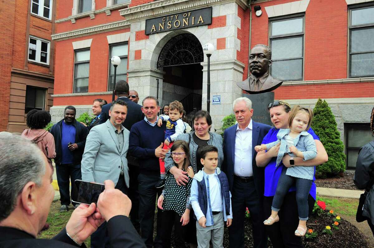 The family of sculptor Vasil Rakaj, second from right, pose together with him in front of the bust of Martin Luther King Jr. that he created, after it was unveiled in front of Ansonia City Hall in Ansonia, Conn., on Saturday May 4, 2019.