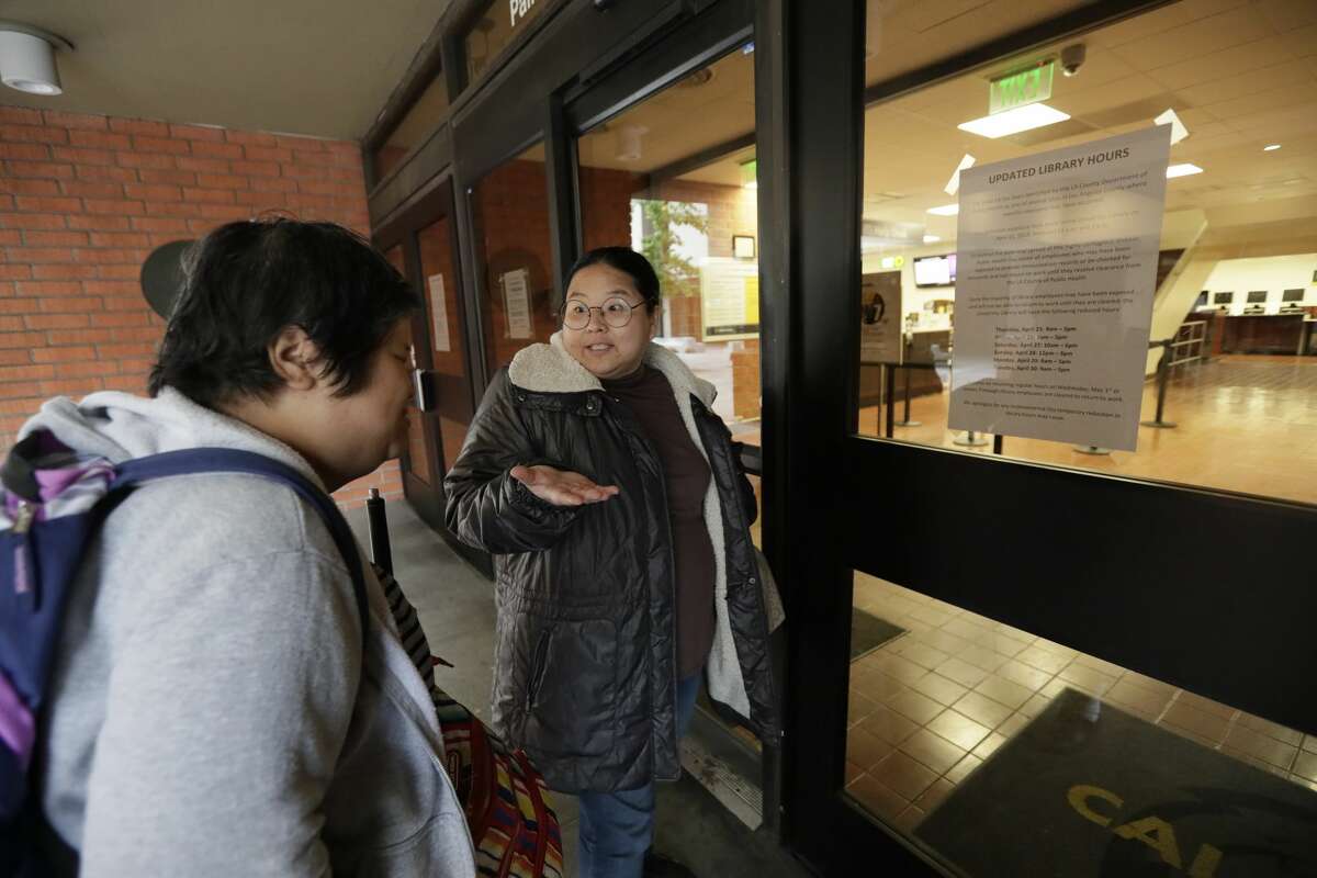 FILE - Sophornia Ko, left, and Marie Choi (who is blind) arrive at John F. Kennedy Memorial Library at Cal State LA that was closed Friday morning, April 26, 2019. A person with a confirmed measles case visited the library at Cal State L.A. on April 11. Seventy-one students and 127 staff members were quarantined at California State University, Los Angeles after a possible measles exposure at a campus library.