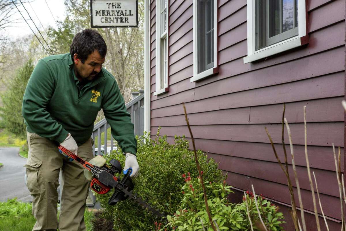 Jesus Alberto-Millanez trims a shrub outside of Merryall Center for the Arts. He was one of 38 volunteers for YardApes, Inc, a landscaping company in New Milford, that spruced up local nonprofits and a school on April 28, 2019.