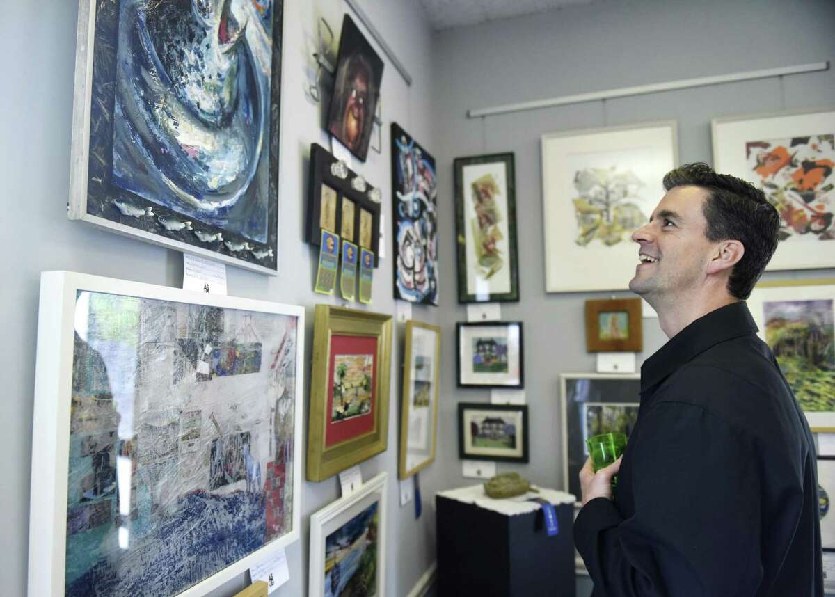 Old Greenwich's Kevin Judge looks at mixed media entries during the opening reception of the Art Society of Old Greenwich's Spring Exhibit and Sale at the Greenwich Botanical Center in the Cos Cob section of Greenwich, Conn. Sunday, May 5, 2019. 83 entries in mediums including oil painting, acrylic painting, watercolor, photography, mixed media, drawing, and sculpture are displayed at the Botanical Center through May 23.