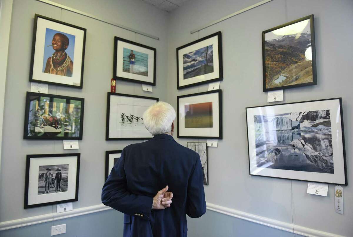 A man looks at photography entries during the opening reception of the Art Society of Old Greenwich's Spring Exhibit and Sale at the Greenwich Botanical Center in the Cos Cob section of Greenwich, Conn. Sunday, May 5, 2019. The artwork — including oil paintings, acrylic paintings, watercolors, photographs, mixed media items, drawings and sculptures — are on display through May 23 at the Greenwich Botanical Center, 130 Bible St., Cos Cob.