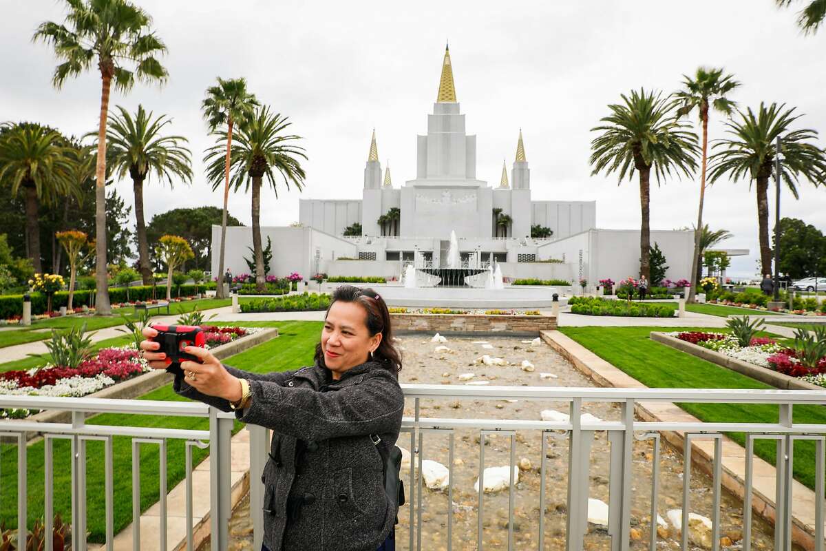 Mary June Burns, a member of the Church of Jesus Christ of Latter-day Saints takes a selfie with the Mormon Temple in Oakland, California, on Monday, May 6, 2019. The interior recently completed extensive renovations.