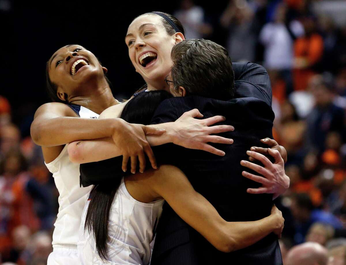 UConn’s Morgan Tuck, left rear, Moriah Jefferson, front left, and Breanna Stewart hug coach Geno Auriemma, right, after winning the NCAA championship game against Syracuse on April 5, 2016, in Indianapolis.