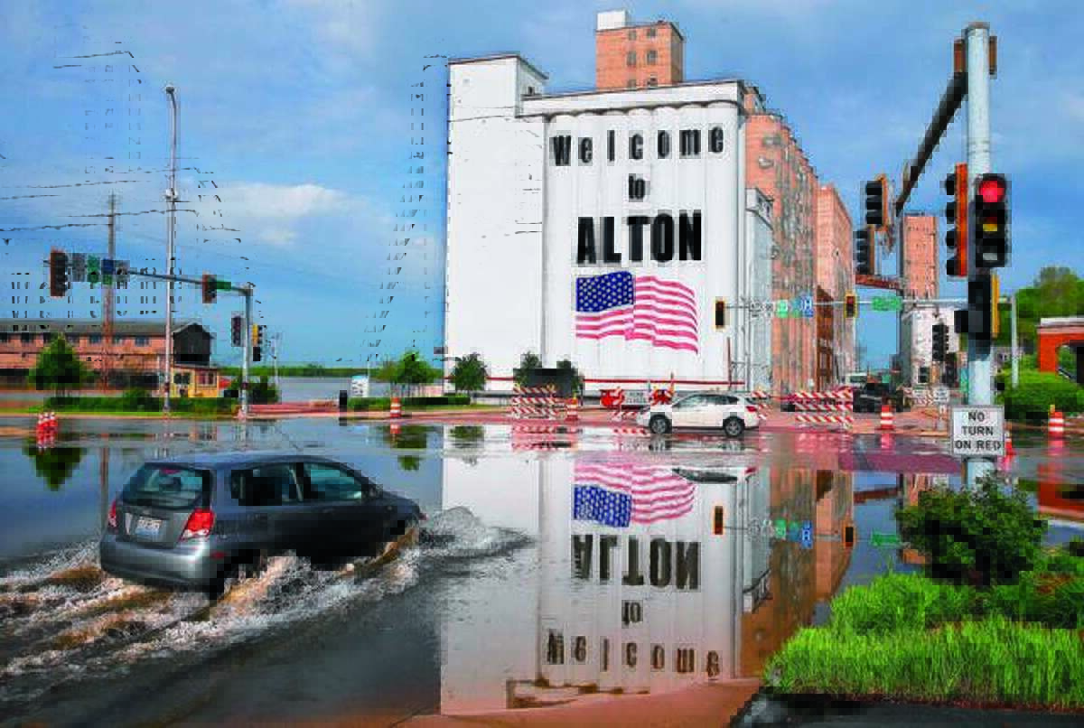 A vehicle drives through Mississippi River flood water in downtown Alton, on Monday. Flooding from the Mississippi River closed streets in downtown, forced the closure of Argosy Casino and flooded the basements of several businesses. The Mississippi River is expected to crest at 34.8 feet later on Monday, almost 14 feet above flood stage. The red painted line beneath the American flag on the grain silos denotes the height of flood water in 1993.