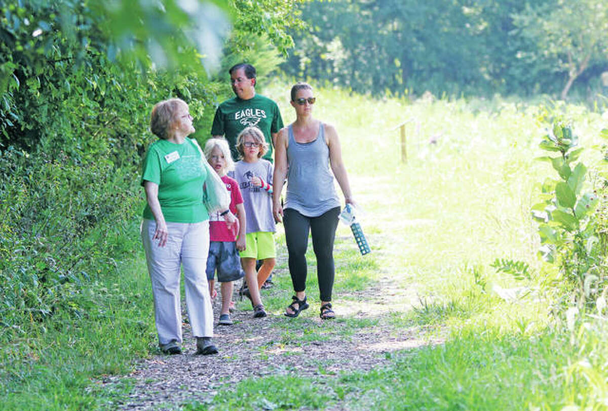 In this July 2017 file photo, Master Naturalist Judy Lincoln, left, leads the monthly “Wilderness Walk” at the Watershed Nature Center in Edwardsville. The nature park is an area the city and university are working on ways to enhance and protect via the SIUE Successful Communities Collaborative (SSCC).