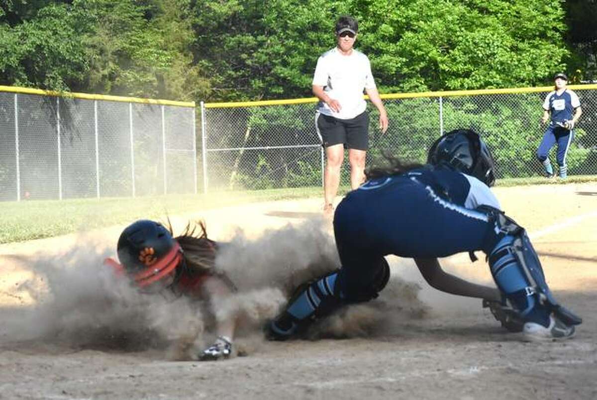 Edwardsville’s Jayna Connoyer slides safely into home plate to give the Tigers a 6-1 lead over Belleville East.
