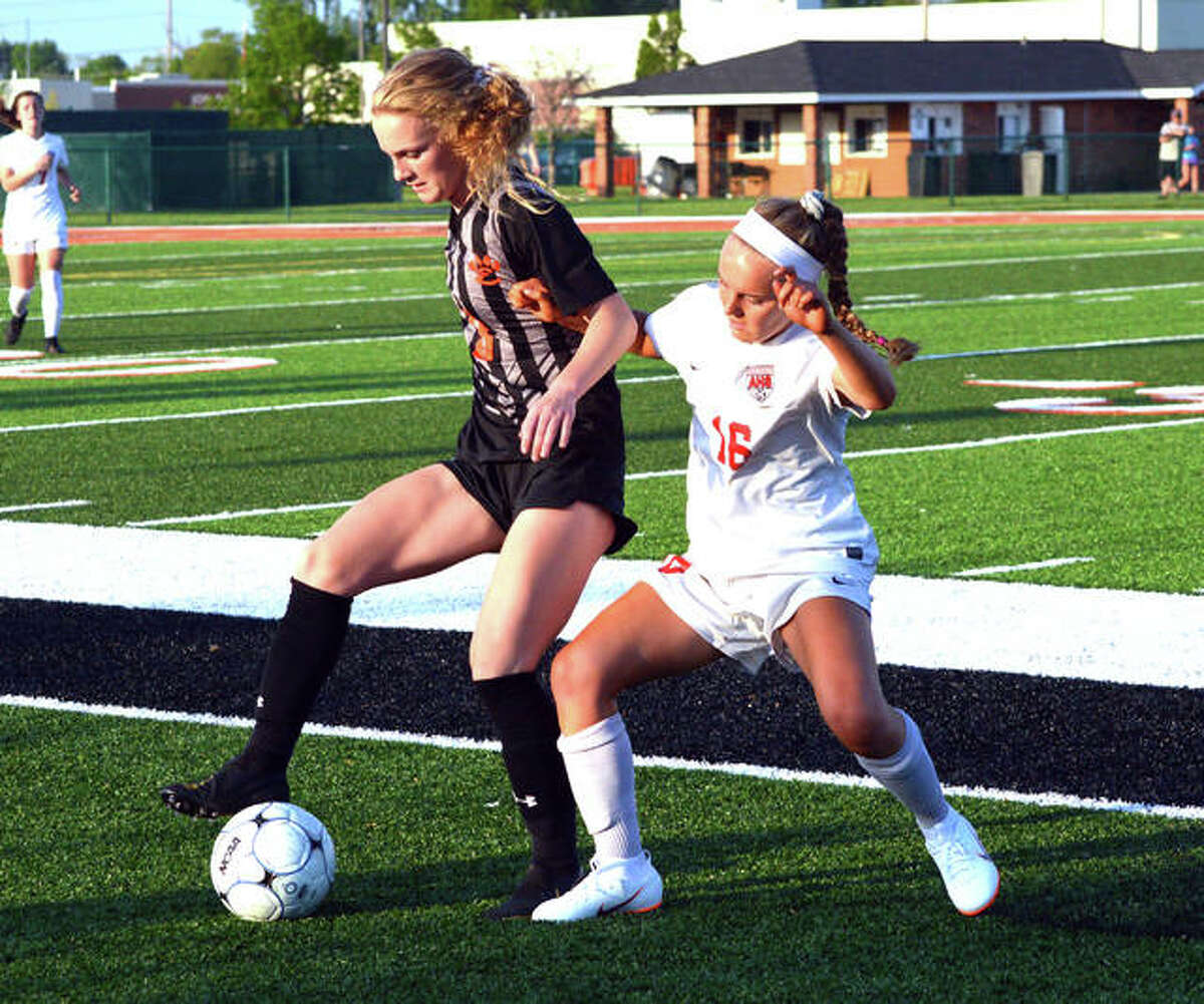 Edwardsville’s Payton Federmann, left, tries to keep the ball away from Alton’s Kaija Ufert during the first half of Tuesday’s game at EHS.