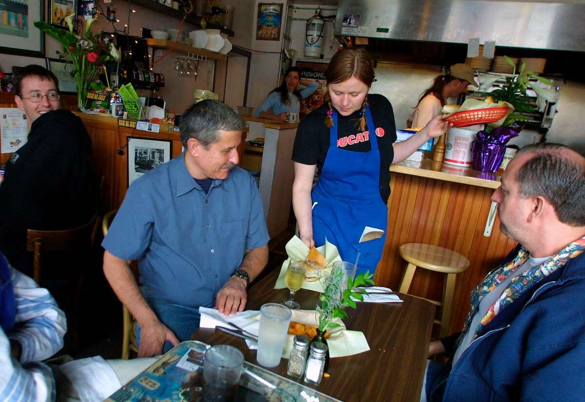 WBLUNCHc-C-30MAR02-SF-KW - L to R: Brad Beck of Oakland looks over to see the po boys being served to Larry Tucker and John Cortez of San Francisco by serverAmber Burnett during the lunch rush at Cajun Pacific Restaurant, on Irving and 47th Avenue in San Francisco. (In the background is chef/owner Chuck Maddox (right) and wife Katie Maddox. SAN FRANCISCO CHRONICLE PHOTO BY KAT WADE
