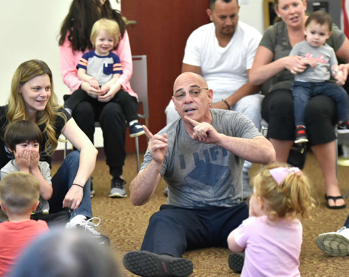 North Haven, Connecticut - Wednesday, May 8, 2019: Librarian Joe "Coach Joe" DeFrancesco leads the "Kids Rock" program Wednesday morning for children 6-months to 5 and their parents engaging them in music, movement, songs, and children's book stories at the North Haven Memorial Library.