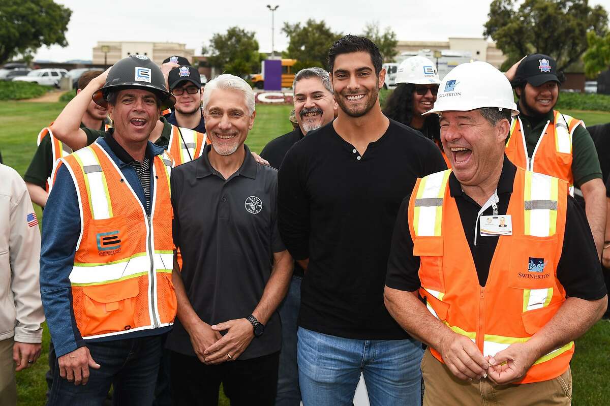 San Francisco 49ers quarterback Jimmy Garoppolo and his father Tony, center left, a former electrician, pose for a group picture with electrical instructor Ray Sugden, left, and construction tech teacher Kurt Cheetsos, at the Inaugural National Signing Day celebrating high school seniors entering skilled trades at Silicon Valley Career Technical Education in San Jose on Monday May 8, 2019.