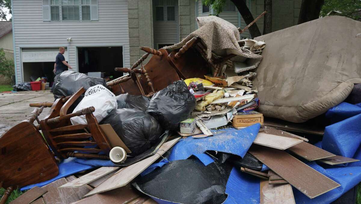 Jay Dabbracio walks by all the furniture damaged by the floodwater in his home on May 8 in Kingwood.
