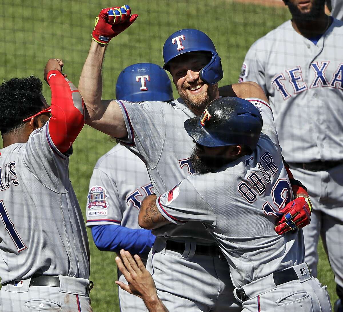 Texas Rangers' Hunter Pence, center, is congratulated by Rougned Odor (12) and Elvis Andrus (1) as he returns to the dugout after hitting a grand slam off Pittsburgh Pirates relief pitcher Michael Feliz during the eighth inning of a baseball game in Pittsburgh, Wednesday, May 8, 2019. The Rangers won 9-6.(AP Photo/Gene J. Puskar)