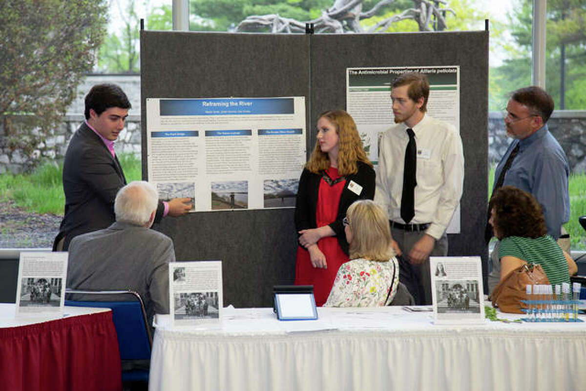 Lewis and Clark Honors College student Ethan Kercher, far left, discusses his group project on river attitudes with his classmates and expo guests.