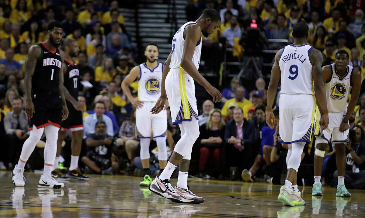 Golden State Warriors' Kevin Durant, center, limps off the court during the second half of Game 5 of the team's second-round NBA basketball playoff series against the Houston Rockets on Wednesday, May 8, 2019, in Oakland, Calif. (AP Photo/Ben Margot)