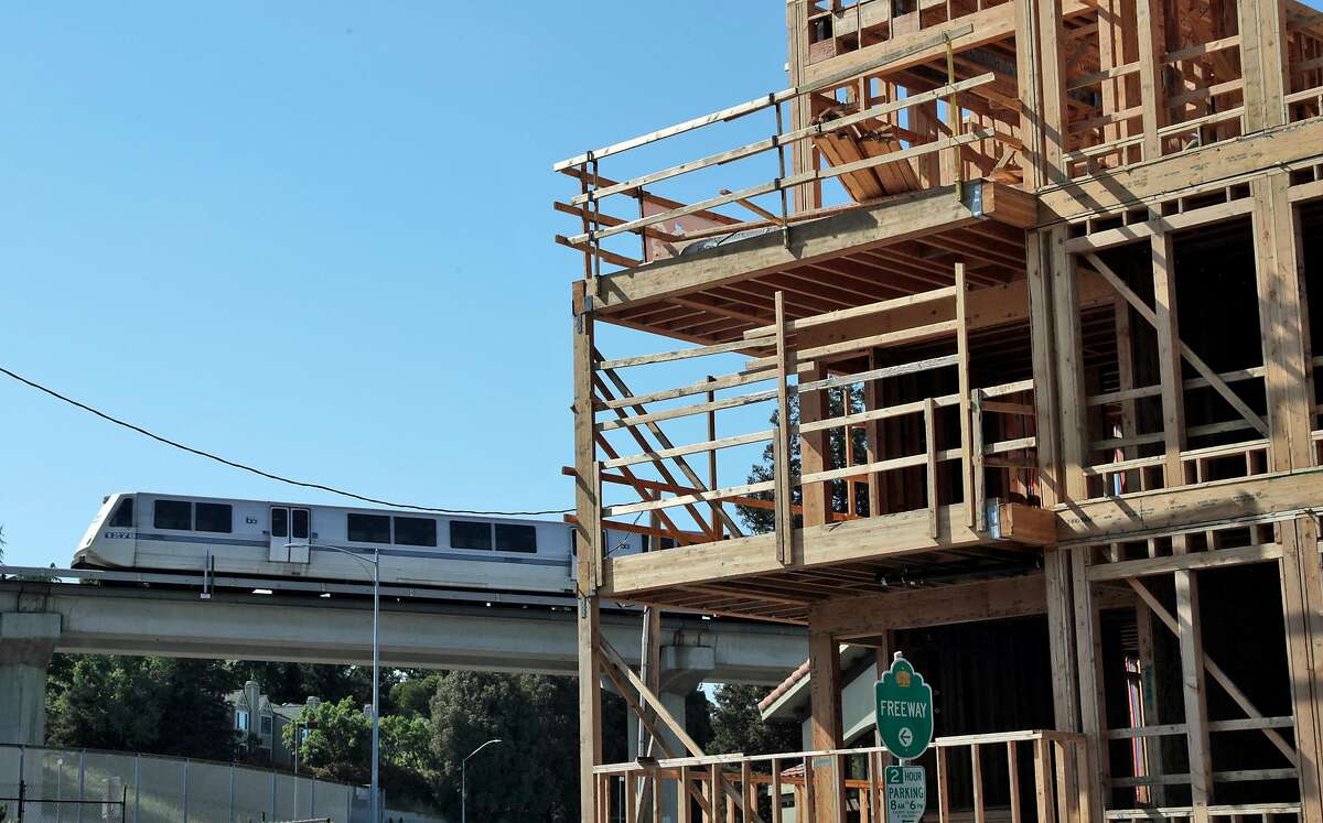A BART train moves by new, luxury condo construction on Trinity Avenue in Walnut Creek, Calif., on Sunday, May 5, 2019. State Sen. Scott Wiener's SB50, besides allowing denser housing near transit, would wipe out single-family zoning in many suburban cities and allow apartment construction in such areas.