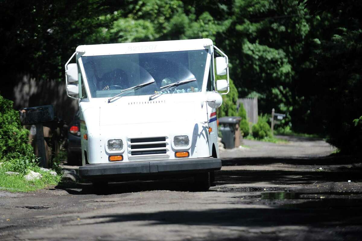 A postal worker had to zigzag down Brookside Dr. to avoid potholes while delivering mail in Stamford, Conn. on Tuesday, June 26, 2018. On Saturday, May 11, U.S. Postal Service letter carriers will conduct the largest one-day food drive in the nation. To participate, place a box or can of non-perishable food next to your mailbox before your letter carrier delivers mail. The donations are sorted and delivered to a food bank.