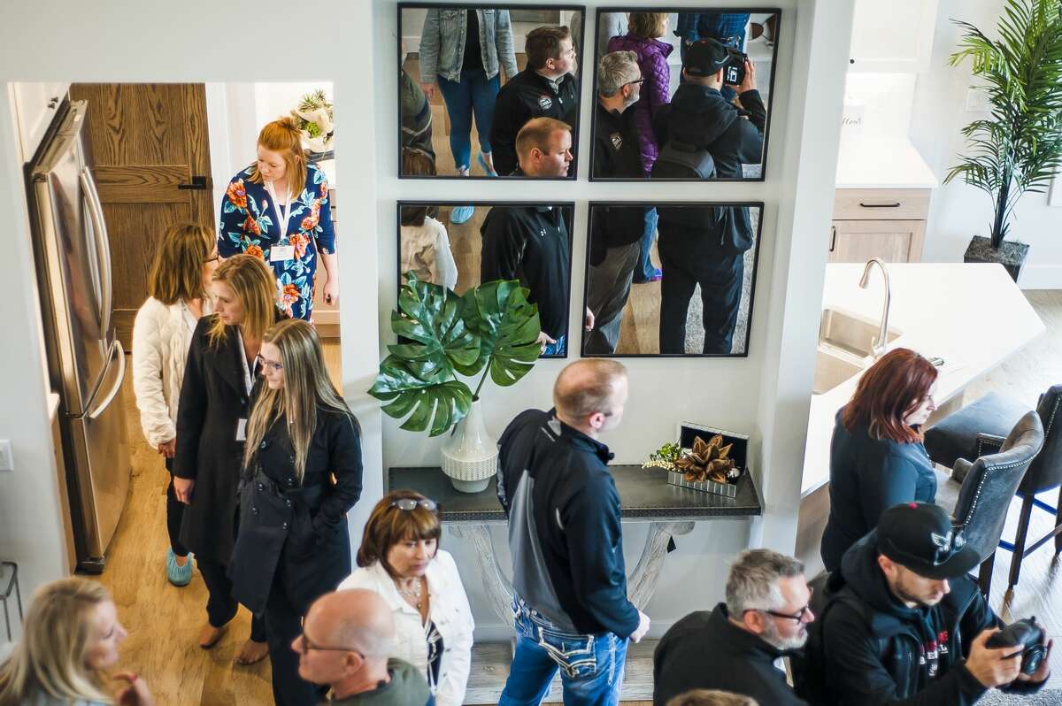 Guests tour a custom built home by Greystone Homes, the proceeds of which will benefit Midland's Open Door programs assist homeless mothers, during a ribbon cutting ceremony to commemorate its completed construction on Wednesday, May 8, 2019 at 3060 Alderberry Court in Midland. (Katy Kildee/kkildee@mdn.net)
