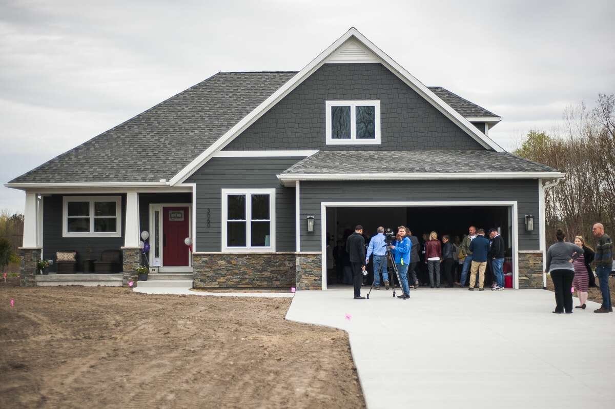 Guests arrive for a ribbon cutting ceremony to commemorate the completed construction of a custom built home by Greystone Homes, the proceeds of which will benefit Midland's Open Door programs assist homeless mothers, on Wednesday, May 8, 2019 at 3060 Alderberry Court in Midland. (Katy Kildee/kkildee@mdn.net)