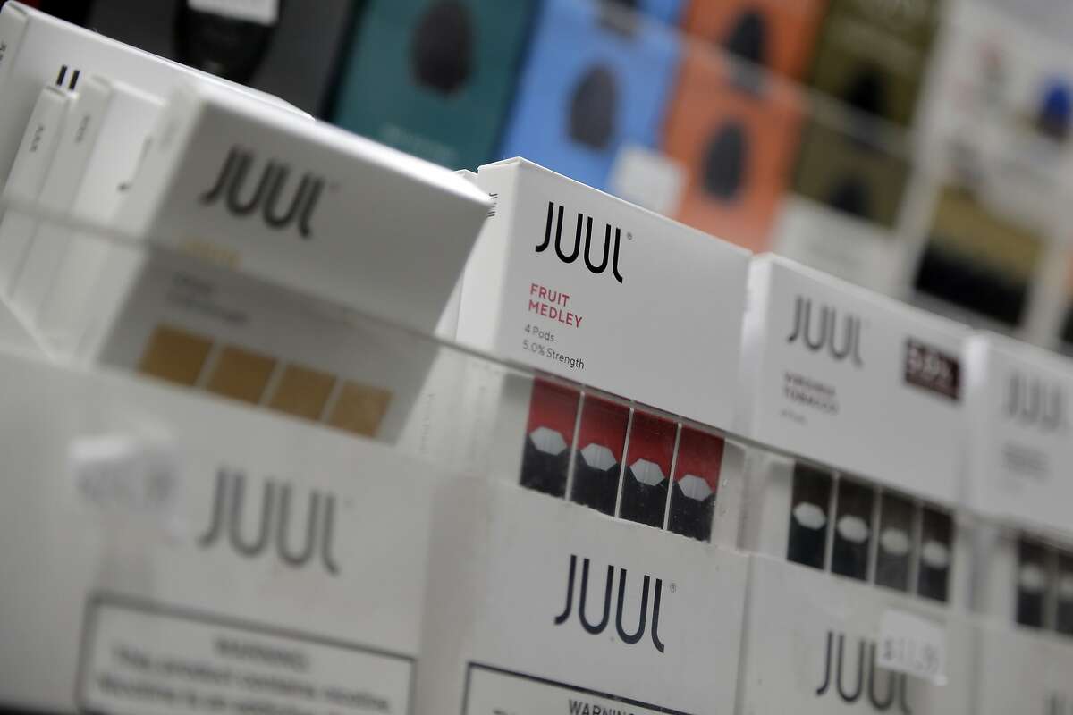 FILE - In this Dec. 20, 2018, file photo Juul products are displayed at a smoke shop in New York. Under scrutiny amid a wave of underage vaping, Juul is pushing into television with a multimillion-dollar campaign rebranding itself as a stop-smoking aid for adults trying to kick cigarettes. (AP Photo/Seth Wenig, File)