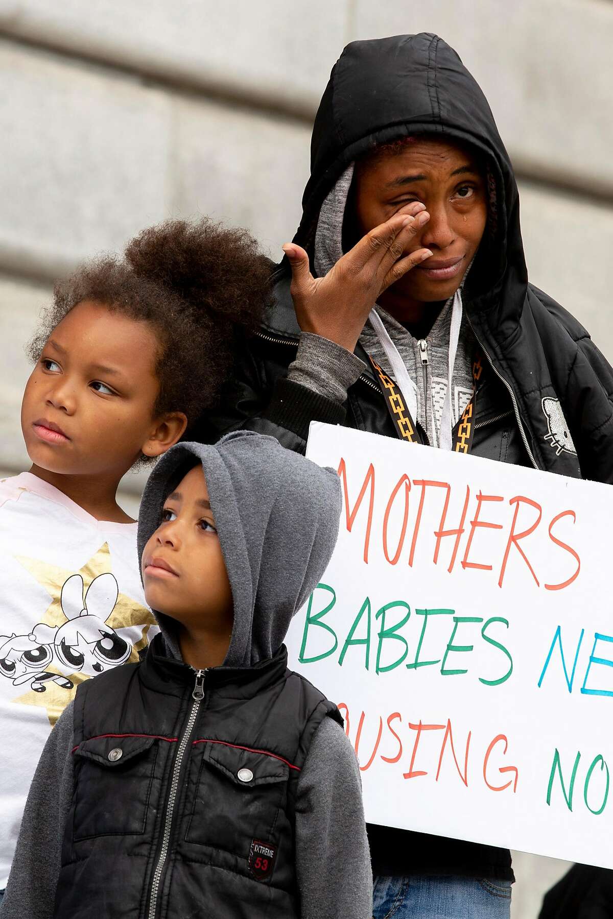 Dinahya Hairston with her children Marjorie Miles, 6, and Stephen Miles, 5, protest outside City Hall on Thursday, May 9, 2019, in San Francisco, Calif. Homeless mothers and their supporters rallied to demand the city for housing subsidies, navigation centers and shelter funding for homeless families. Hairston is living with her children in a homeless shelter for families.