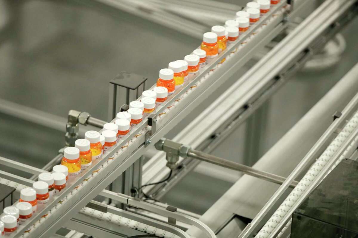 Bottles of medicine ride on a belt at the Express Scripts mail-in pharmacy warehouse in Florence, N.J.
