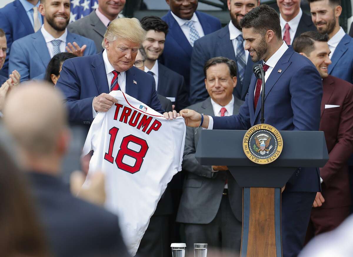 Outfielder J.D. Martinez, right, presents a team jersey to President Donald Trump, left, during a ceremony on the South Lawn of the White House in Washington, Thursday, May 8, 2019, where Trump honored the 2018 World Series Baseball Champion Boston Red Sox.