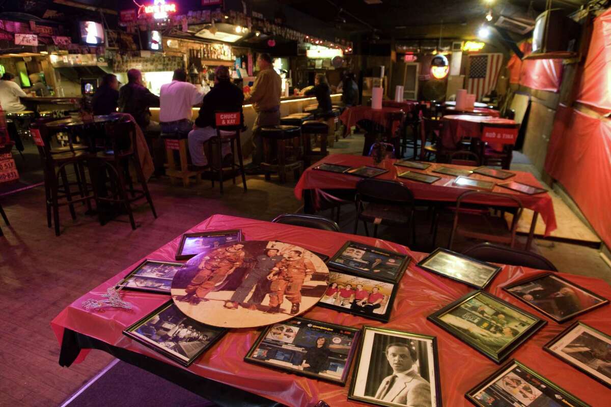 Historic photos from the space program are shown on a table at the Outpost Tavern in Webster. A NASA-area hangout for astronauts and regular folks, the bar closed in 2009 but hopes remain it could reopen someday.
