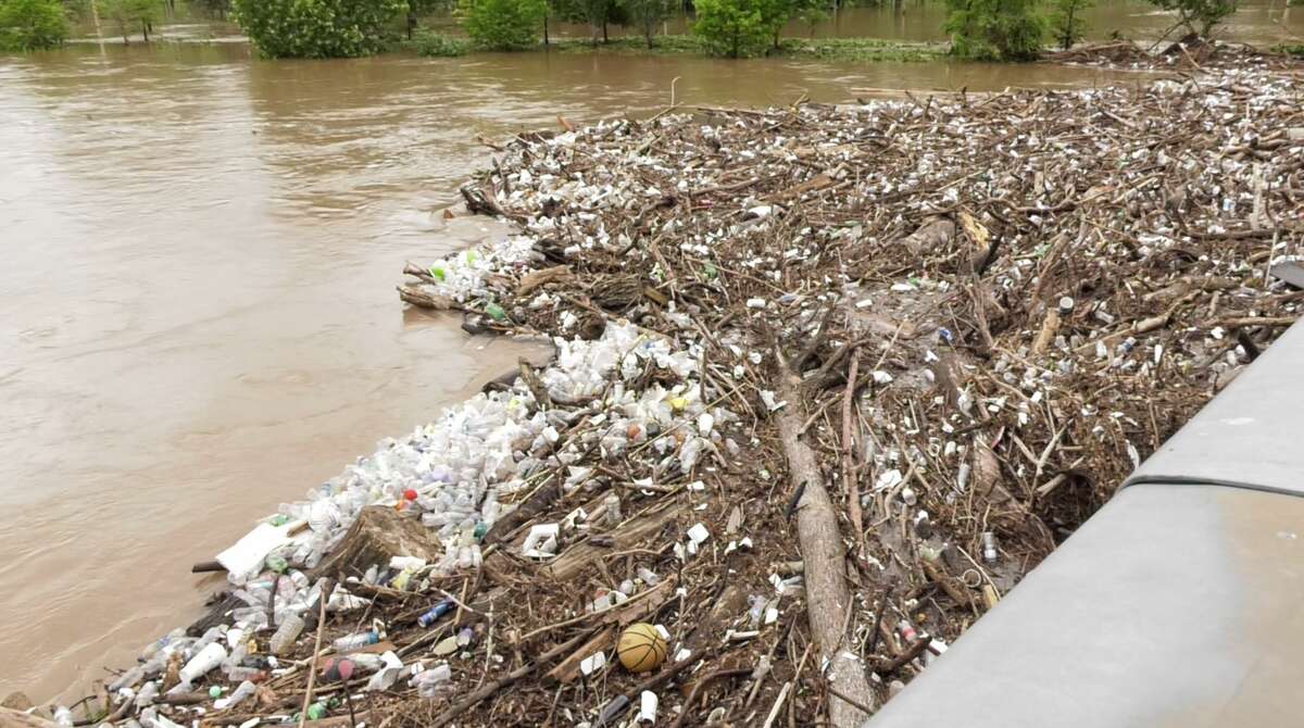 Debris and trash build up on the Carruth Pedestrian Bridge over Buffalo Bayou west of downtown Houston after heavy rains on Friday, May 9, 2019.