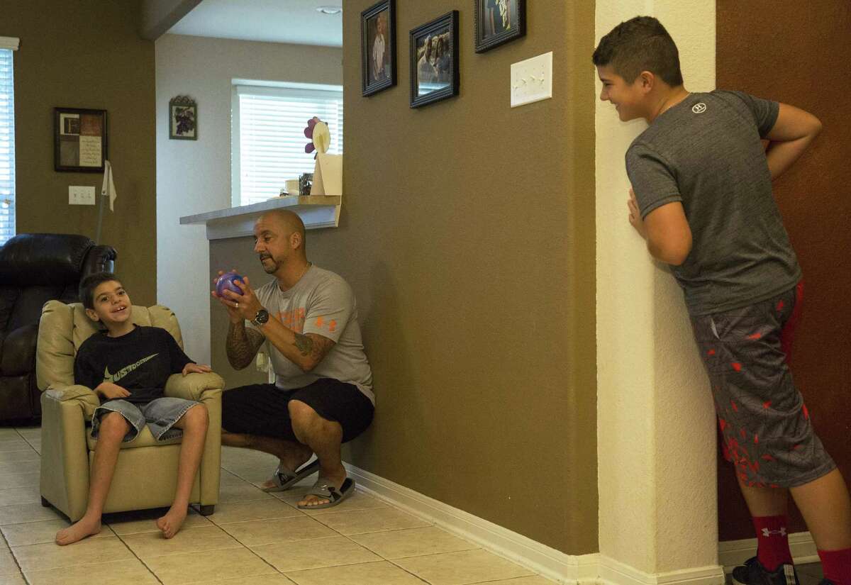 Nicholas Cantu, 9, waits for his father, James, to assist him aiming and throwing the ball at his brother, Noah, 12, while the family is playing with him Friday, June 30, 2017, in Spring. Nicholas has significant disabilities after being born premature and his parents are worried that potential reductions to Texas for Medicaid as part of the Senate's bill to repeal and replace the Affordable care Act will chip away at the day to day services they need to not only keep Nicholas alive but also help them manage his care. ( Yi-Chin Lee / Houston Chronicle )