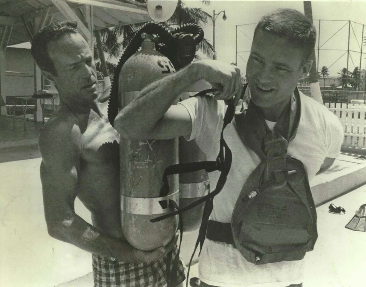 In this 1967 photo, Scott Carpenter, left, the second American to orbit Earth after John Glenn, helps John S. Bull, 32, one of the newest and youngest astronauts at the time, to "suit up" for scuba training. Bull, of Memphis, Tenn., was a test pilot before joining the space program. Carpenter is a veteran aquanaut who spent 30 days underwater in the SEALAB II project.
