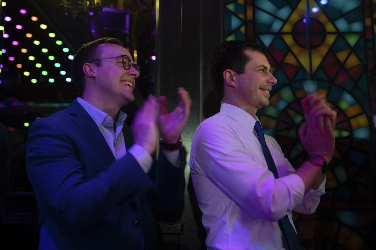 Democratic presidential candidate Pete Buttigieg, right, and husband, Chasten Glezman, listen to a speech while waiting to be introduced at a campaign event May 9, 2019, in West Hollywood, Calif.