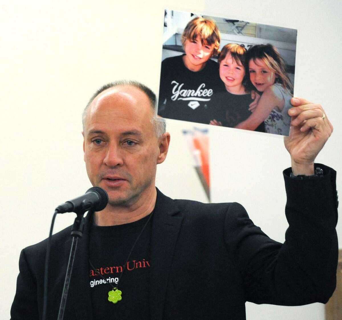 Sandy Hook Promise founder Mark Barden, who lost his son Daniel at Sandy Hook, holds up a photo of his children as the Wilton Quaker Meeting of the Religious Society of Friends hosts a Remembrance Vigil for All Victims of Gun Violence Saturday, December 8, 2018, at their facility in Wilton, Conn. The event was associated with the 6th Annual National Vigil being held in Washington, D.C. Wednesday.