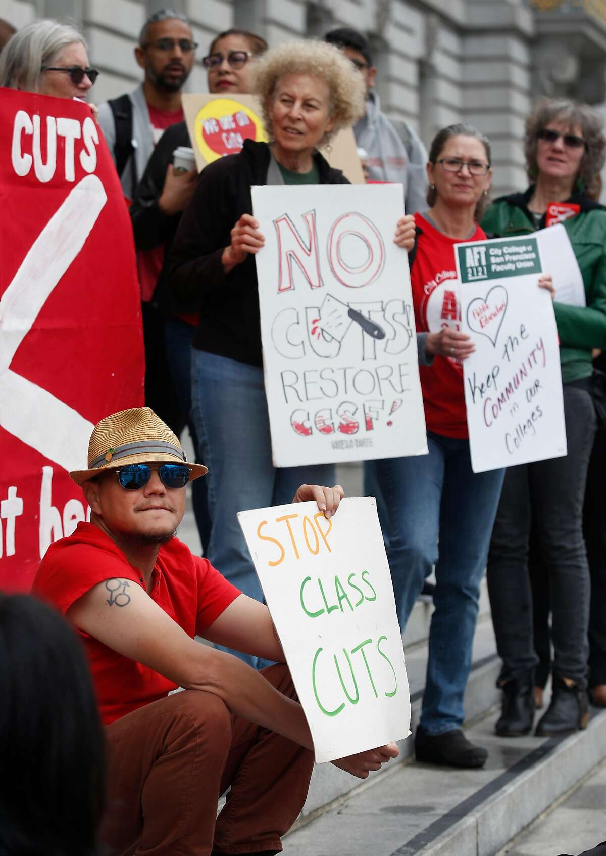 Anakh Sul Rama (lower left) joins students, faculty and members of the community concerned about proposed cuts at CCSF in a rally on the steps of City Hall before a hearing convened by the Joint City, School District and City College Select Committee in San Francisco, Calif. on Friday, May 10, 2019.