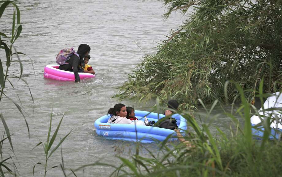 The group of nine migrants from Honduras and El Salvador almost made it across the swollen river the inflatable pools before two tipped over. Agents on the riverbank tossed rescue ropes to help them get on dry land. Two agents jumped in to help them. Photo: Bob Owen / ©2019 San Antonio Express-News