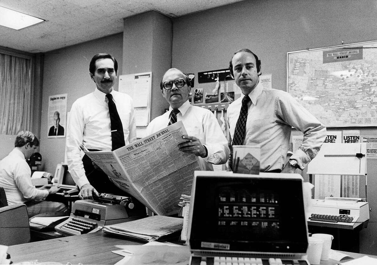 FILE — Warren Phillips, left, The Wall Street Journal’s publisher, with Ray Shaw, center, and Peter Kann in the paper’s newsroom in Manhattan in 1979. Phillips, who started as a $40-a-week proofreader, rose through the ranks and eventually presided over a vast expansion of the business newspaper’s influence and reach, died on May 10, 2019. Joe was 92. (Vic DeLucia/The New York Times)