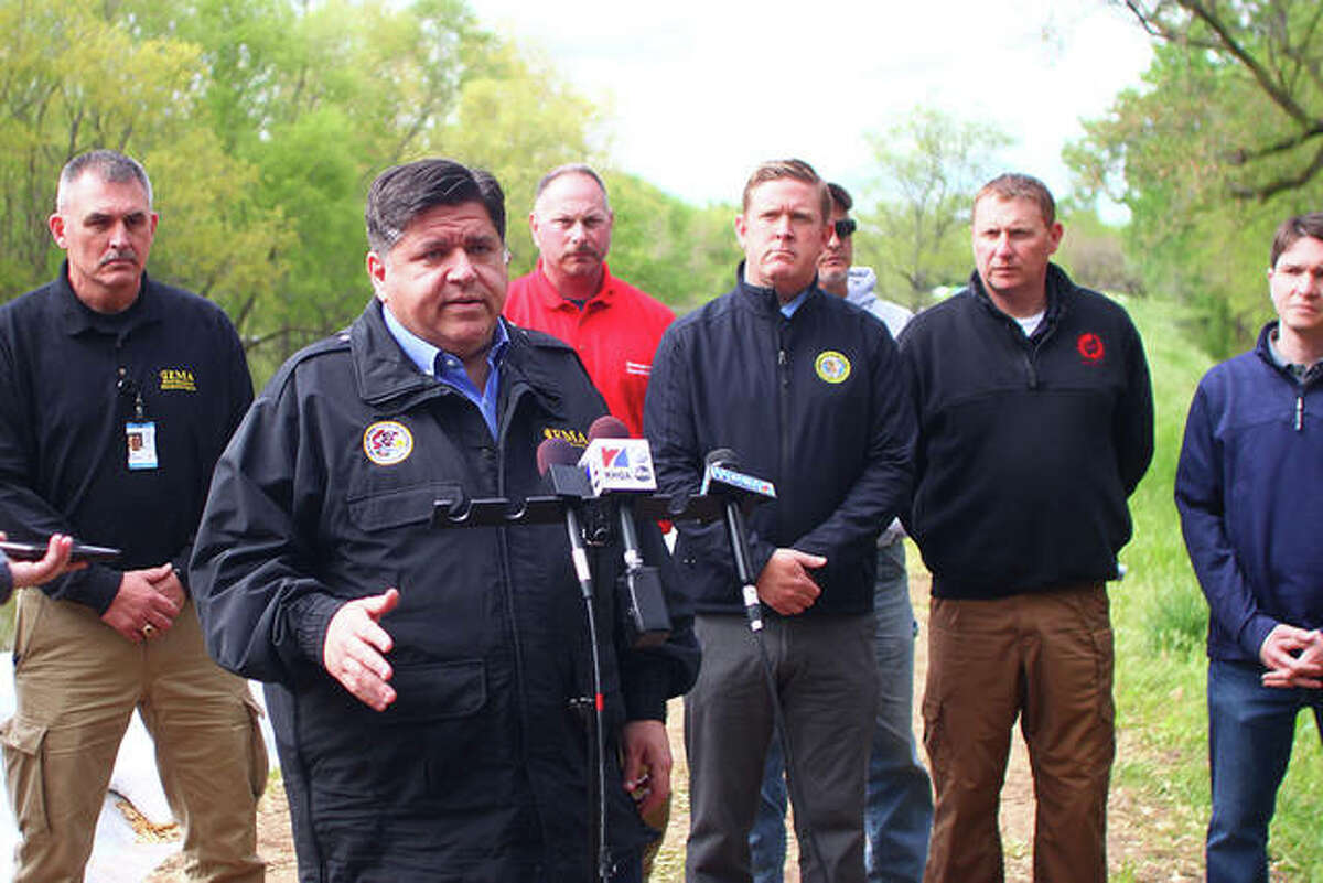Gov. J.B. Pritzker speaks during a press conference on one of the levees along the Illinois River in Meredosia.