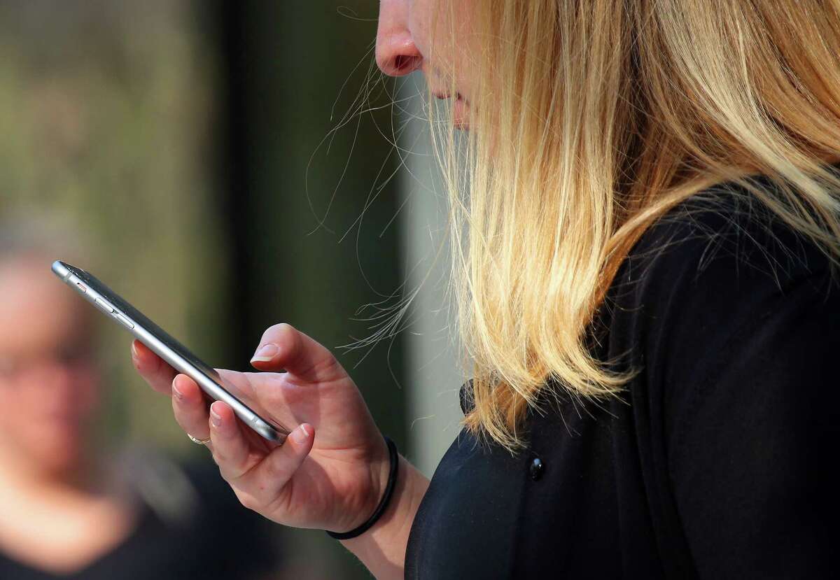 FILE -- A woman looks at her smartphone in Palo Alto, Calif., on Aug. 19, 2016. The Federal Communications Commission is warning of a robocall that can lead consumers to be billed toll charges similar to calling a 900 number. (Jim Wilson/The New York Times)