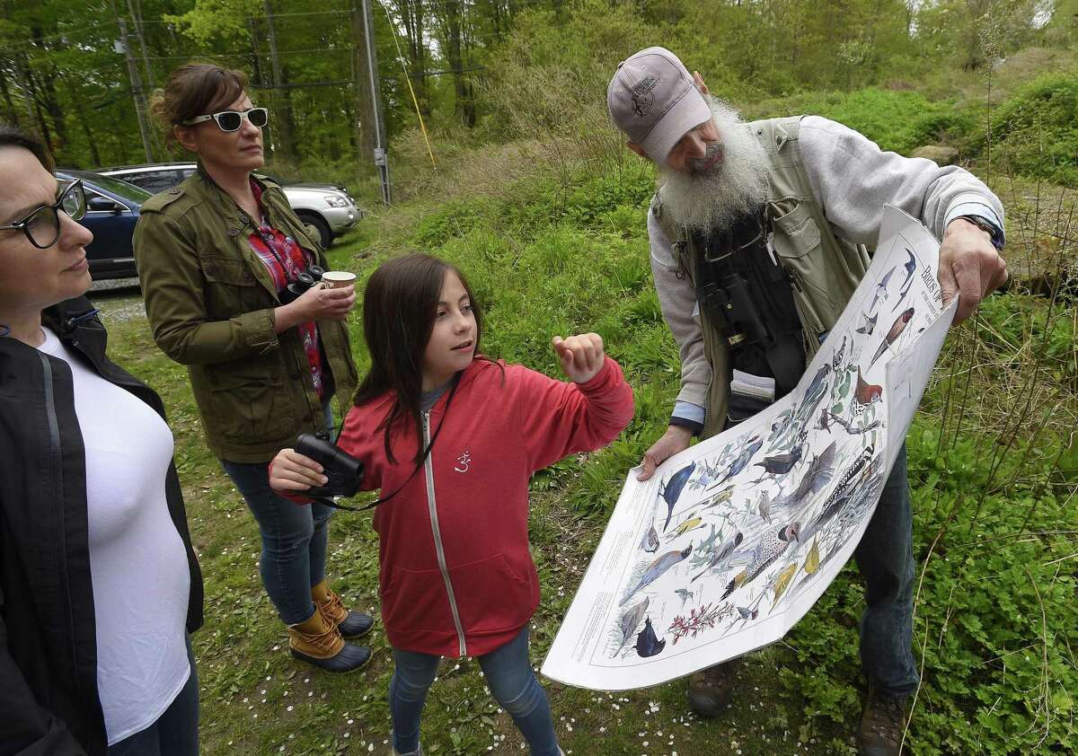 Ruby Siano, 10, of Rye, N.Y., points out her favorite bird from a chart that Ted Gilman, an education specialist and senior naturalist with Audubon Greenwich, was using to identify migrating birds during an observance of World Migratory Bird Day on May 11, 2019 in Greenwich.