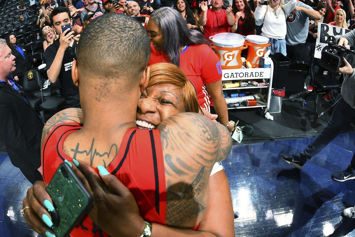Portland Trail Blazers guard Damian Lillard is hugged by his mother, Gina Johnson, after the second half of Game 7 of an NBA basketball second-round playoff series Sunday, May 12, 2019, in Denver. The Trail Blazers won 100-96. (AP Photo/David Zalubowski)
