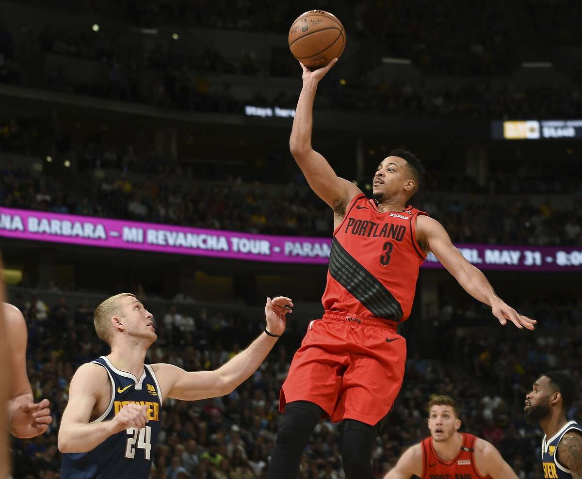 Portland Trail Blazers guard CJ McCollum, right, flies over Denver Nuggets forward Mason Plumlee for a basket in the second half of Game 7 of an NBA basketball second-round playoff series Sunday, May 12, 2019, in Denver. The Trail Blazers won 100-96. (AP Photo/John Leyba)